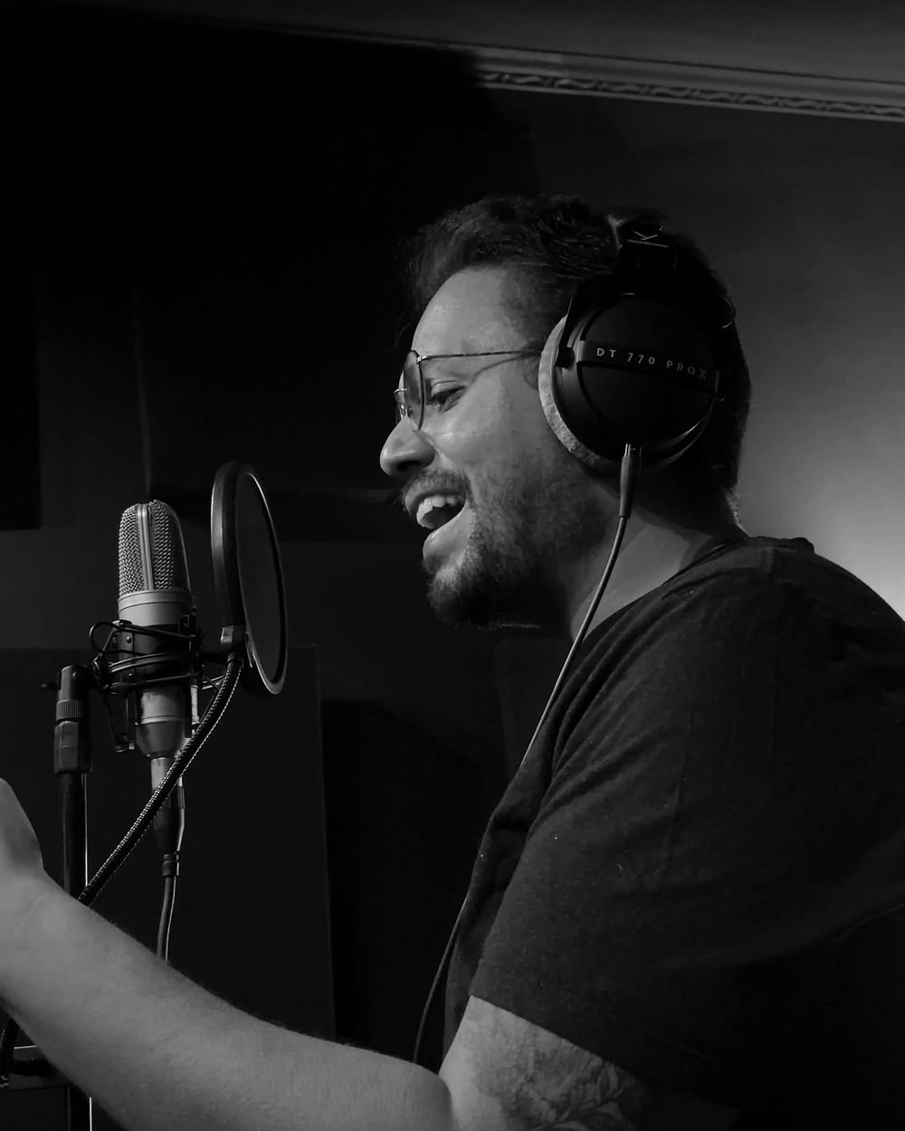 Diego Ganden, vocalista da VELT, cantando no estúdio, em preto e branco